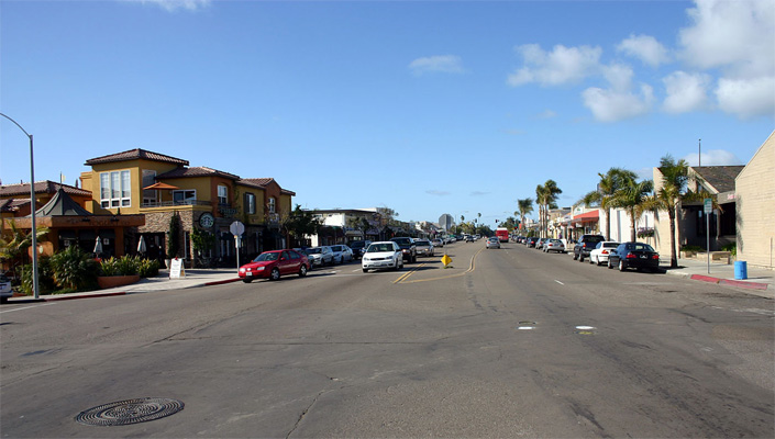 photo shows an intersection 6 lanes wide -- one lane is for parking, and the middle lane is painted to designate a refuge island